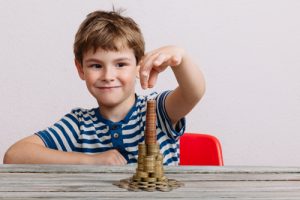 Boy building a stack of money