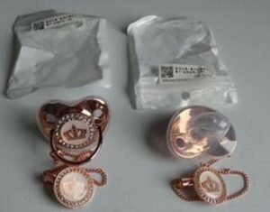 This image shows a rose gold babies dummy.