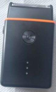 A black shaver with an orange rim near the shaver head.