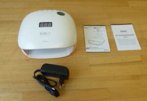 White UV Nail Lamp with a digital display on top and a black 2-pin plug beside it.
