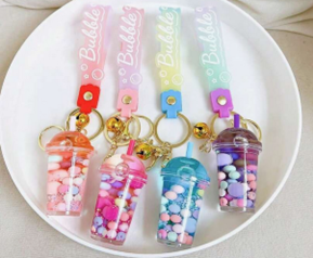 An image of four bubble tea-shaped keyrings in four different bright colours.