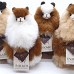 4 plush alpacas in brown, beige and white, all of similar sizes.