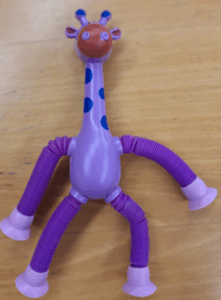 An image of a purple giraffe with blue spots on its neck.