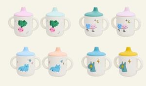 White sippy cups with lids of various colours and cartoon pictures on the sides